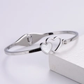 Detail of silver heart-shaped shell bangle with sparkling zircon stone on stone prop - Shell Heart Bangle / Silver
