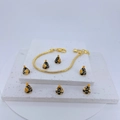 Detail of gold snake chain bracelet with black and gold conical charms on stone base - Black/Gold