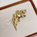 Macro shot of tulip flower bud brooch with gold brushed metal texture on a wooden tray - Gold Leaf Brooch N-14