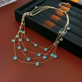 Détail du collier doré multicouche avec pierres de zircon bleues et chaîne d'extension - Or-Bleu