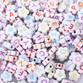 Close-up of white flower-shaped acrylic beads with colorful A-Z alphabet letters for DIY - 5x10mm Flower Letter Beads (100pcs)