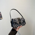Leopard print crossbody bag with black strap and square gold buckle in chic monochrome - Black