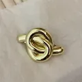 Detailansicht einer goldenen Metall-Haarklammer in Knotendesign auf hellem Hintergrund - Gold