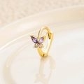 Golden huggie hoop earring with purple zircon butterfly pendant on a beige plate - Gold Purple