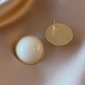 Nahaufnahme cremeweißer Acryl-Ohrstecker mit Goldrand und strukturierter Rückseite - 925 Silberstecker / Runde Ohrstecker