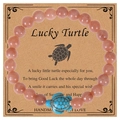 Lucky turtle charm bracelet with pale orange beads and turquoise turtle on display card - Sunstone