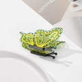 Detalle de una pinza para el cabello de mariposa en acetato verde con pedrería azul en plato - Verde amarillento / 8.6cm