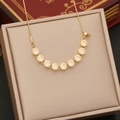 Dettaglio ravvicinato di una collana a stella in zircone dorato in una scatola beige - Stile Disco Tondo Curvo (5#)
