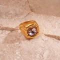 Macro shot of gold stainless steel ring with a purple square-cut zircon stone detail - Pink