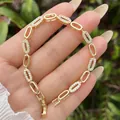 Elegant 18K gold plated bracelet with cubic zirconia oval links held in palm - Gold Oval Link Bracelet