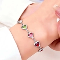 Detailed shot of a colorful heart-shaped crystal bracelet worn on a woman's wrist - Bracelet / Silver