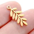 Detailed golden leaf-shaped stainless steel pendant held on fingertips for size comparison - DY747 Long Leaf / Gold