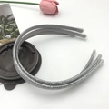Close-up of three sparkling silver and grey glitter headbands with protective end caps - Silver