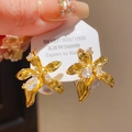 Gros plan détaillé de boucles d'oreilles fleur dorée avec cristaux et poinçon Argent 925 - Tige en Argent 925 - Fleur 3D Blanche et Dorée