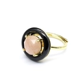 Detail of gold ring featuring faceted pink crystal stone set in a black ceramic circle - Sunstone
