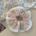 Close-up of colorful plush scrunchie with white lace trim on a cozy knit background - Lace Rainbow Pink