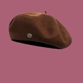 Detailed macro view of wool texture and silver metal buckle on dark brown beret hat - M / Coffee