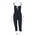 Detail of black yoga romper with delicate white lace trim and bow knot on the chest - XS / Black
