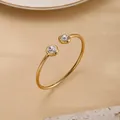 Brazalete dorado minimalista con dos cristales sobre soporte de piedra texturizada - Dorado - Doble Circonia