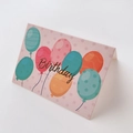 Primer plano de tarjeta de cumpleaños rosa con globos de colores y tipografía - Feliz Cumpleaños Globo