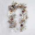 Christmas wreath with white magnolia, pine cones, and festive ornaments on white background - White Magnolia Garland