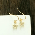 Détail de boucles d'oreilles étoiles dorées avec des pierres de zircone blanches - Étoile Dorée avec Strass