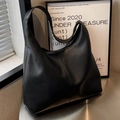 Bolso hobo minimalista en cuero negro con textura de grano suave y correa ancha - Negro