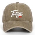 Detail of white Tokyo embroidery and red Japanese text on washed khaki baseball cap - Khaki