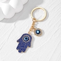 Nahaufnahme von goldener Hand der Fatima und blauem Auge Anhänger mit Kristallen - Goldrand Blaue Hamsa