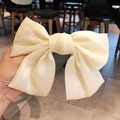 Elegant cream white satin oversized bow hair clip held in hand with smooth silk texture - Creamy White Trending Style