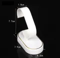 White C-shaped watch display stand with elegant gold-stamped lines and oval base - White Stand With Gold Edge