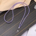 Detail eines lila Glitzer-Lanyards mit silbernem Metalldrehhaken auf Holzoberfläche - Crossbody-Stil / Lila