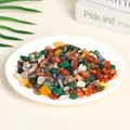 Polished natural assorted crystal stones in a white bowl with floral decor - 100 Grams Of Colored Agate (7-9mm)