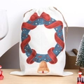 Christmas drawstring gift bag with festive wreath and bell on light wood tabletop - Christmas Wreath & Bells