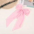 Detailed close-up of a pink satin long ribbon bow hair clip with a smooth silk texture - Pink