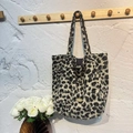 Leopard print plush tote bag with gold metal plaque hanging on a wooden hook - Beige Leopard