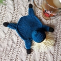 Handmade crochet turtle coaster in blue yarn on a textured knit blanket background - Navy Blue