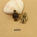 Pair of vintage bronze angel wing charms on kraft paper with a decorative seashell - A2514 Sitting Angel