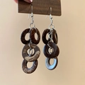 Detaillierte Makroansicht von Vintage-Kokosschalen-Quastenohrringen mit Naturtextur - Kokosnussschalen-Ohrringe (Braun)