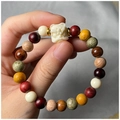 Macro shot of colorful wooden beads bracelet with a white lion guardian carving detail - Lion Style