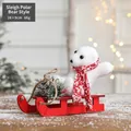Ornamento natalizio orso polare su slitta con sciarpa rossa, pigne e dettagli di neve - Stile Orso Polare sulla Slitta