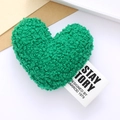 Detailed view of green plush heart-shaped accessory with embroidered fabric label tag - Green