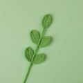 Macro detail of handmade crochet green leaf sprig with intricate knitted stitch textures - 5 Leaves / Bean Green