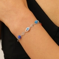 Detailed view of silver chain bracelet with blue evil eye beads on a woman's wrist - Evil Eye Bracelet (G-466) / Silver