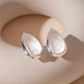 Macro shot of silver teardrop earrings showing brushed texture and polished edges - Minimalist Water Drop Style / Silver Water Drop (Silver Pin)