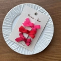 Three-piece set of gradient red ribbon bow hair clips on a white ceramic plate - Bright Red Series