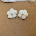 Detailaufnahme von weißem Stoffblumen-Ohrring mit Perlenmitte auf braunem Papiergrund - Silbernadel - Weiße Blumenohrstecker