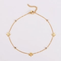 Dettaglio della cavigliera dorata con ciondoli a albero, strass e chiusura a moschettone - Forma dell'albero di Natale / Oro