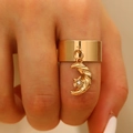 Close-up of a wide gold ring with a sparkling moon and star charm on a finger - Moon Style (N-1067)
