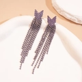 Detail of purple rhinestone tassel earrings with a crystal bowknot on a ceramic plate - Arrow / Purple